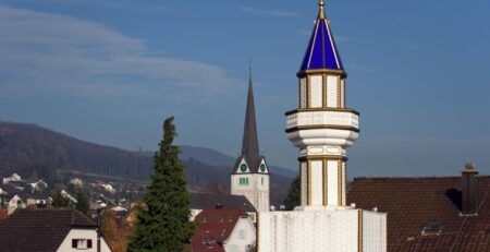 A minaret installed on the roof of a Turkish cultural centre is seen with a church in the background on November 20, 2009 in Wangen bei Olten, northwestern Switzerland