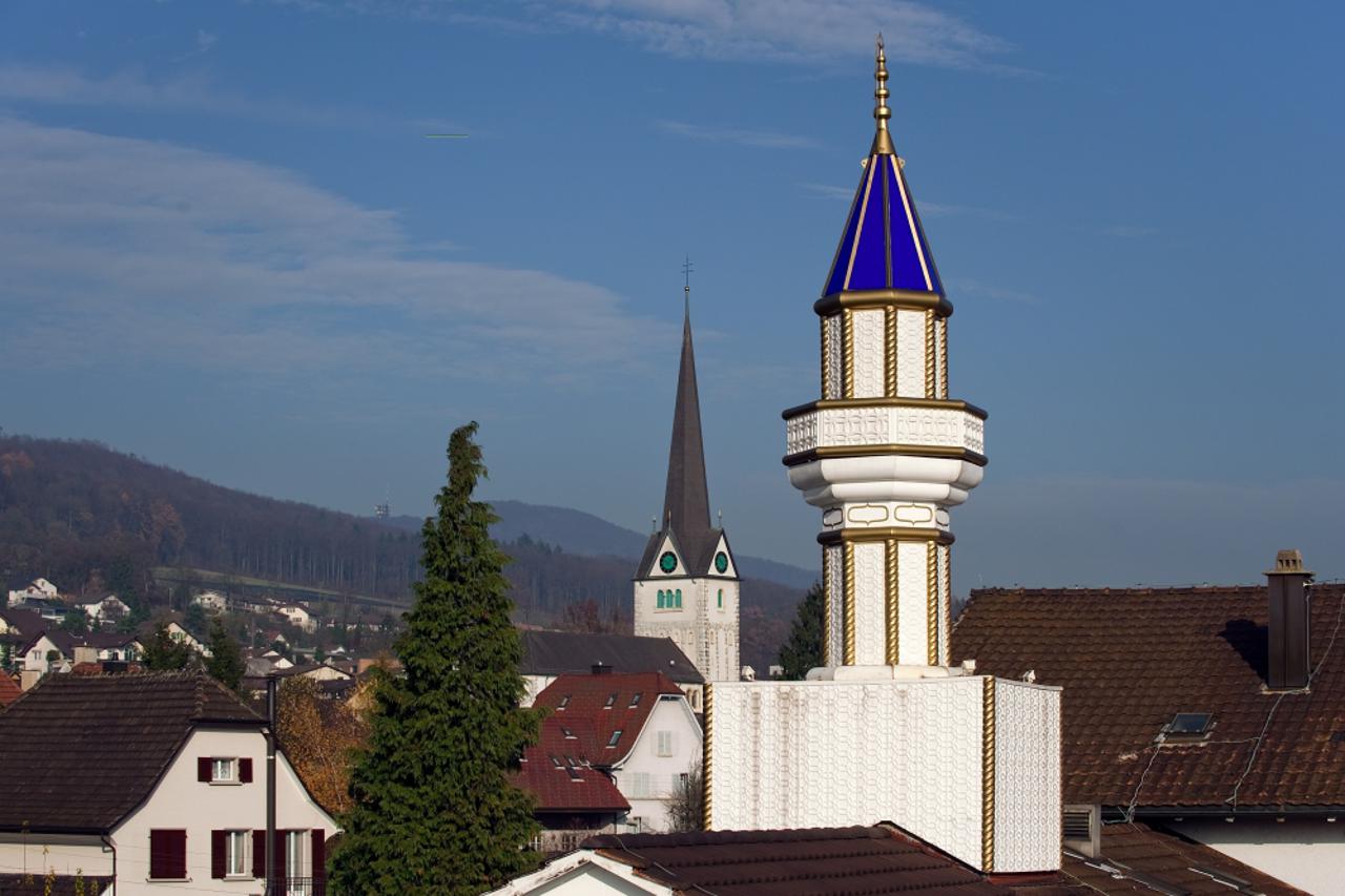 A minaret installed on the roof of a Turkish cultural centre is seen with a church in the background on November 20, 2009 in Wangen bei Olten, northwestern Switzerland